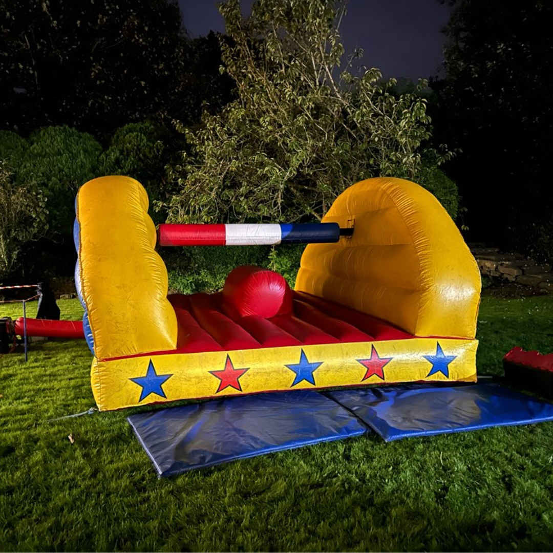 Close-up of inflatable pillow wars arena showing padded beam and soft safety landing area